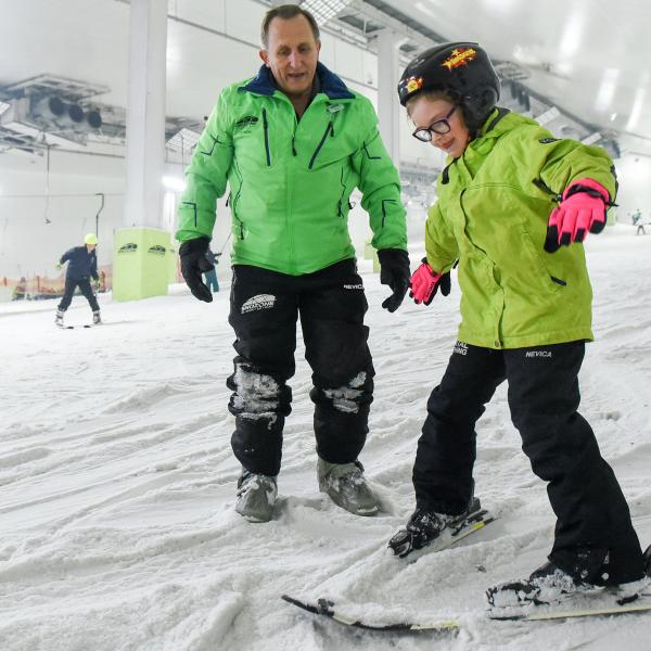 Snozone Coach with Child on Skis in Adaptive Ski Session